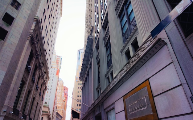 Photo street view of new york stock exchange, or nyse, on wall street in financial district of lower manhattan, new york of usa. skyline and cityscape with skyscrapers at united states of america, nyc, us