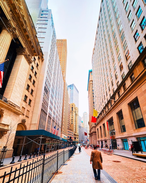 Street view of New York Stock Exchange, or NYSE, on Wall Street in Financial District of Lower Manhattan, New York of USA. Skyline and cityscape with skyscrapers at United States of America, NYC, US