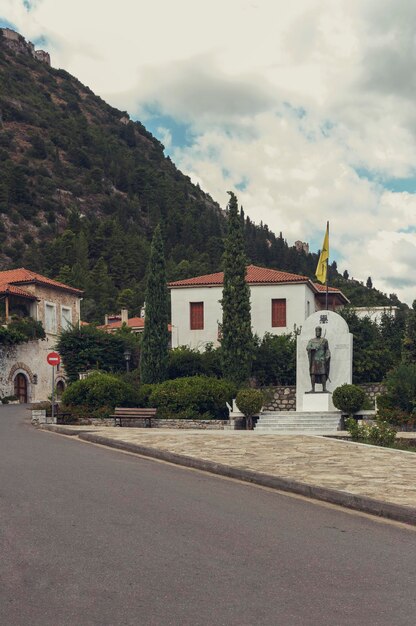 Street with stone houses and memorial in the village closeup