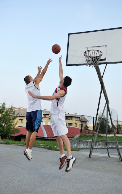 Streetball basketbalspel met twee jonge spelers in de vroege ochtend op het stadshof