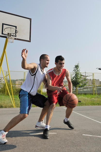 streetball basketbalspel met twee jonge spelers in de vroege ochtend op het stadshof