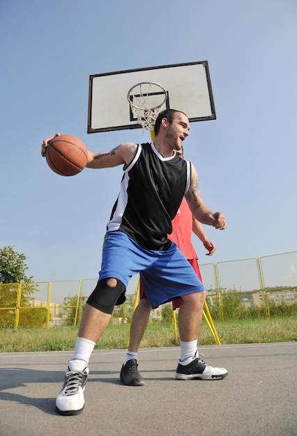 streetball basketbalspel met twee jonge spelers in de vroege ochtend op het stadshof