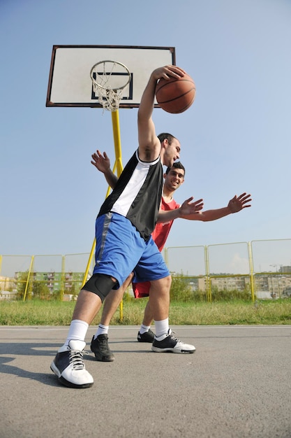 streetball basketbalspel met twee jonge spelers in de vroege ochtend op het stadshof