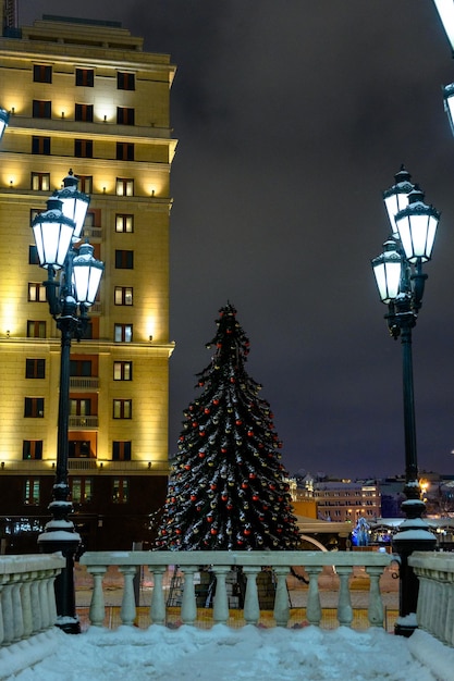 새해 전야 눈보라 동안 크리스마스 트리와 화환으로 장식된 도시의 거리