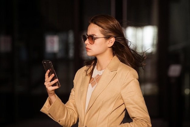 Streetstyle-foto van elegante modieuze zakenvrouw die trendy kleding draagt en telefoneert...