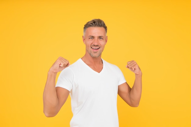 Strength and power Happy bachelor show strength Strong man flex arms yellow background Strength and confident Strength comes from within