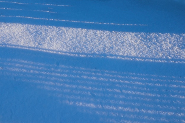 Foto strepen van schaduwen op een besneeuwd veld op een zonnige winterdag