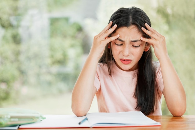 Stress angst en zorgen met een klein meisje dat worstelt met haar studie onderwijs en thuis leren Verward gefrustreerde en overstuur student die problemen heeft met huiswerk en moeilijke studie