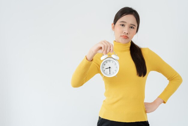 Foto stress azië jonge vrouw laat klokalarm zien dame is te laat op afspraak of op werk of in de klas studeren verslapen moeite met opstaan in de ochtend tijd bezorgd niet op tijd slaperig over tijd schiet op tijd