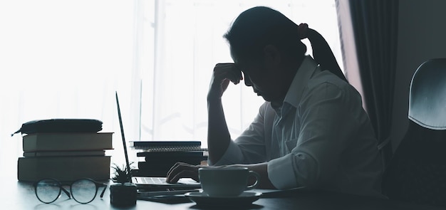 Stress business woman person from hard work depression in office Tired and anxious employee female with unhappy at problem job young businesswoman sitting sad front of laptop computer on desk