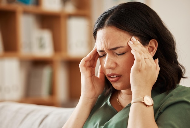 Stress hoofdpijn en vrouw op een bank met duizeligheid hersenmist of burn-out in haar huis migraine angst en vrouw in een woonkamer met probleem falen of crisis vermoeidheid of geestelijke gezondheidsprobleem