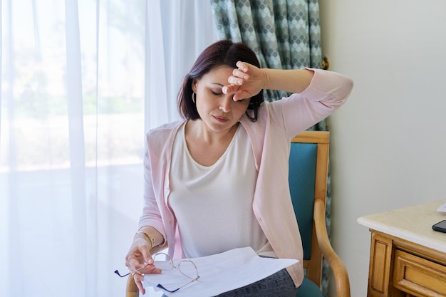 Stress hoofdpijn migraine overstuur vrouw van middelbare leeftijd die haar hoofd met haar handen vasthoudt