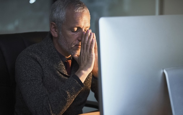 Photo the stress is starting to get to him cropped shot of a mature businessman looking stressed while working late at the office