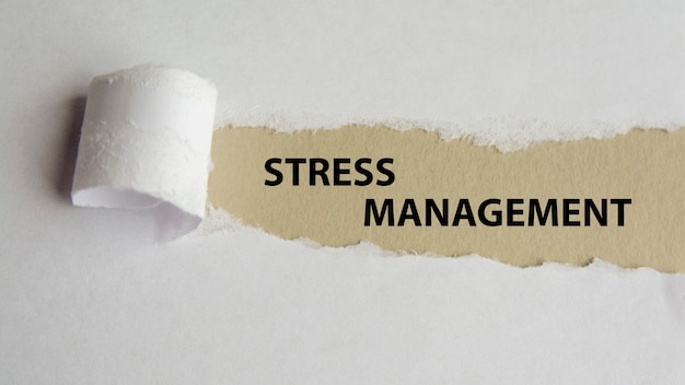 Stress management. woorden. tekst op grijs papier op gescheurd papier achtergrond.