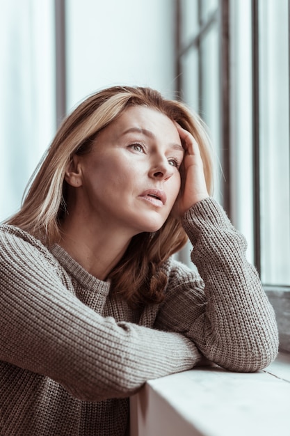 Stress na ruzie. vrouw met bruine trui voelt zich erg gestrest na ruzie met echtgenoot with