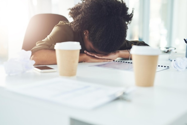 Stress sleeping and tired business woman in office with fatigue overworked and exhausted from working Burnout nap and African female worker overwhelmed for deadline workload and pressure at desk