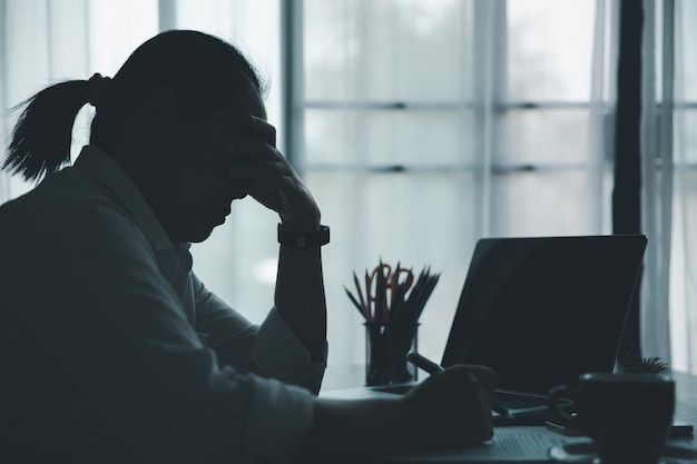 Stress zakenvrouw van hard werken depressie op kantoor vermoeide en angstige werknemer vrouw met ongelukkige problemen op de baan jonge zakenvrouw die verdrietig voor de laptop zit op het bureau