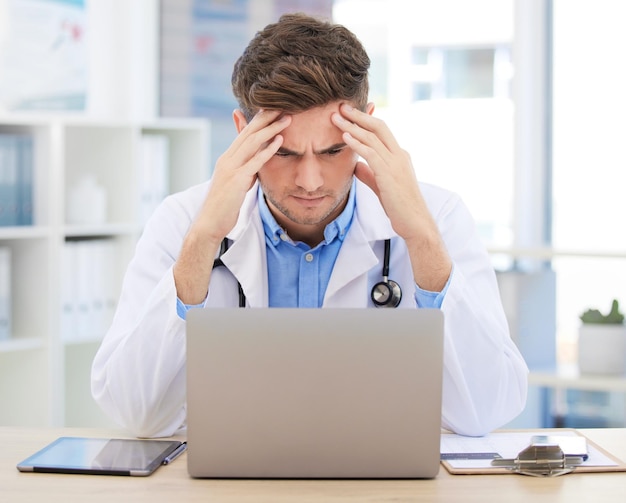 Stressangst of burn-out voor arts met laptop die werkt aan geneeskunde, medisch of gezondheidszorgonderzoek Hoofdpijn, hoofdpijn of migraine voor ziekenhuismedewerker of carrièreman met digitale technologie