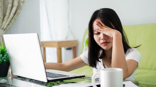 Stressed Asia woman work from home with computer at home