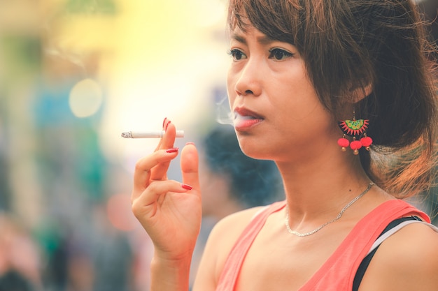 Stressed asian woman addiction smoking a cigarette in vintage style