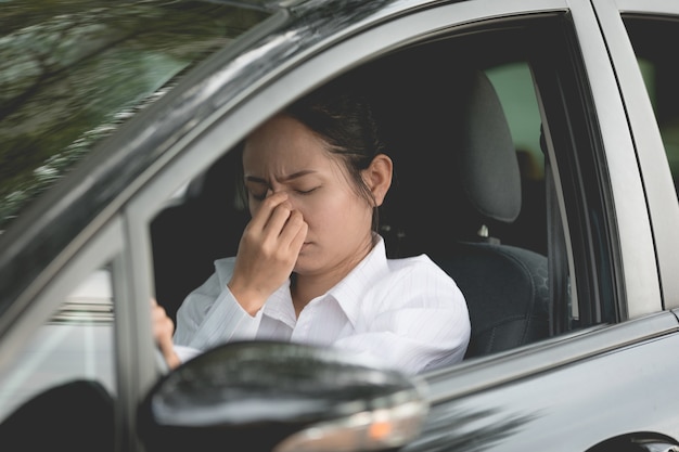 彼女の車の中に座っているアジアの女性ドライバーのストレス