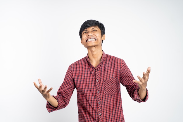 Stressed asian young man scream isolated on white