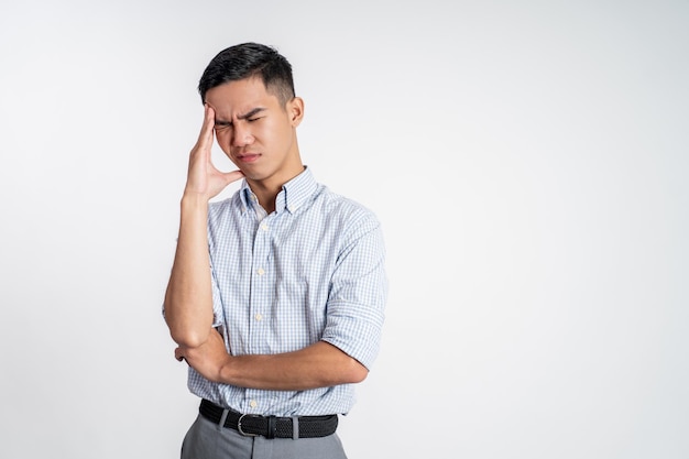 Stressed asian young young man holding head