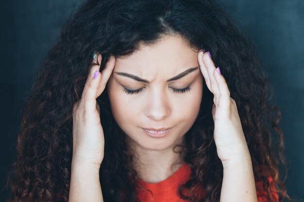 stressed brunette lady.  emotional woman massaging temples. headache