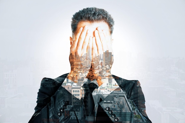 Stressed businessman covering face multiexposure