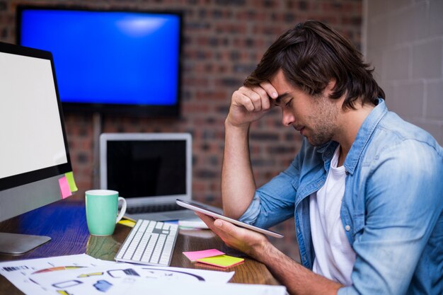 Stressed businessman holding digital tablet