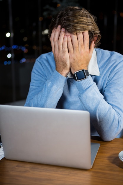 Stressed businessman sitting at his desk