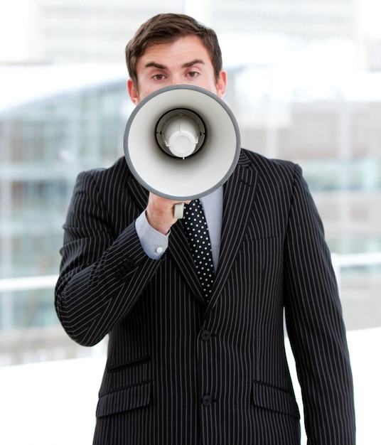 Stressed businessman yelling through a megaphone 