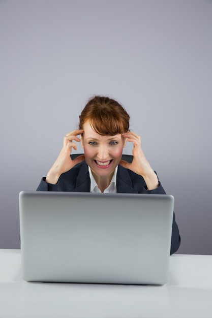 Stressed businesswoman working on laptop