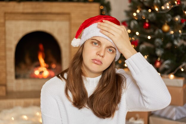 頭痛を持っているストレスの多いクリスマスの女性