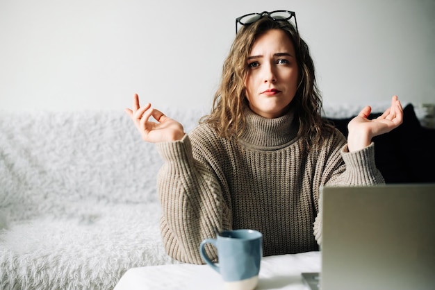 Stressed female accountant working remotely from home facing laptop issues or financial report