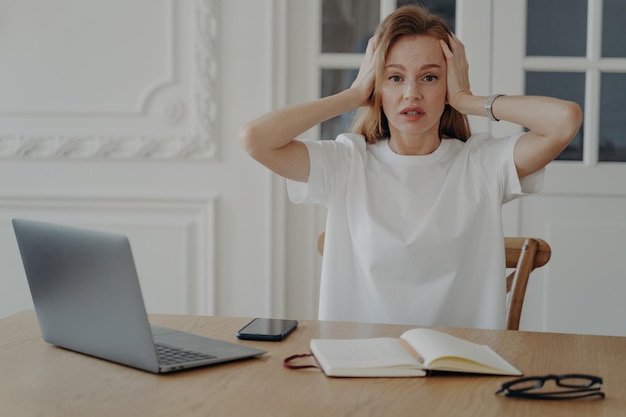 노트북으로 책상에 앉아 문제 해결을 생각하는 스트레스를 받는 여성