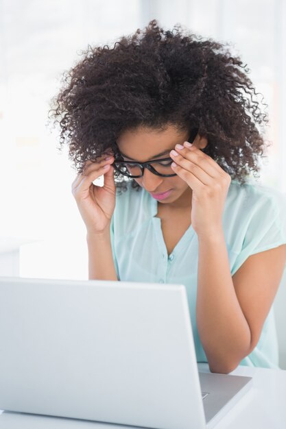 Stressed hipster businesswoman working on laptop