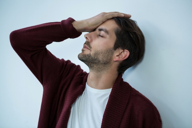 Stressed man leaning on wall