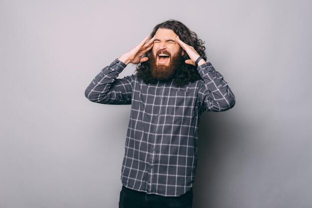 Stressed man screaming loud in studio