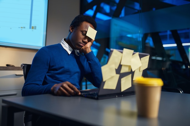 Stressed manager works on laptop, night office lifestyle