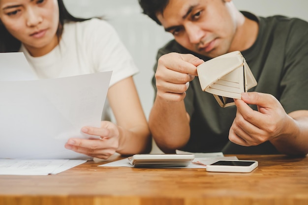 Foto problema stressato asiatico giovane coppia uomo donna calcolare prestito aperto portafoglio vuoto borsa senza soldi per pagamento fattura carta di credito o spesa fallimento fallimento o debito ipotecario finanziario