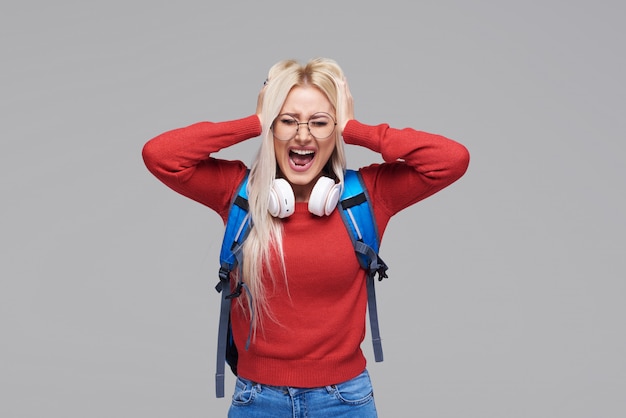 Stressed scared female student  covering her had, feeling afraid of stressful examination at college, screams loudly. ashamed teenage girl feeling frustrated, hiding herself behind palms