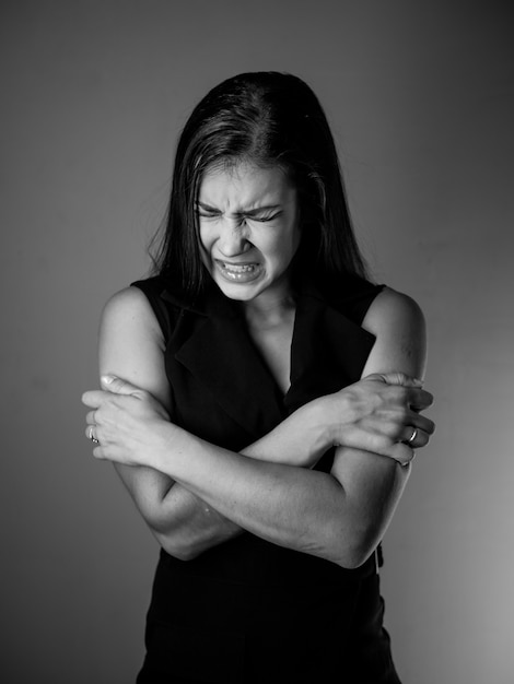 Stressed and scared woman on grey background