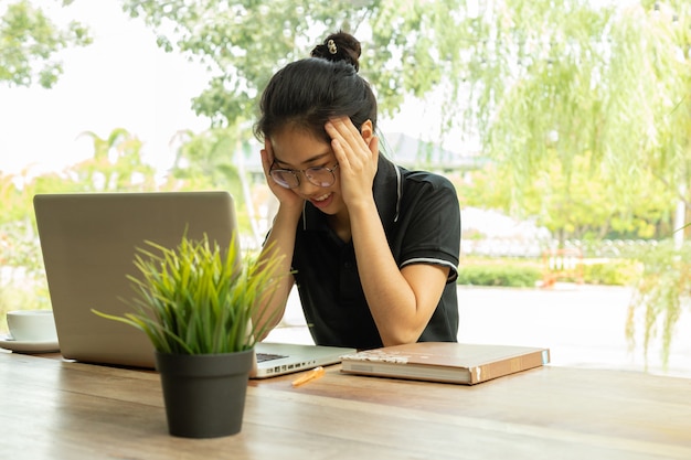 Stressato studente sensazione dolore improvviso dopo aver usato a lungo il computer portatile per lo studio.