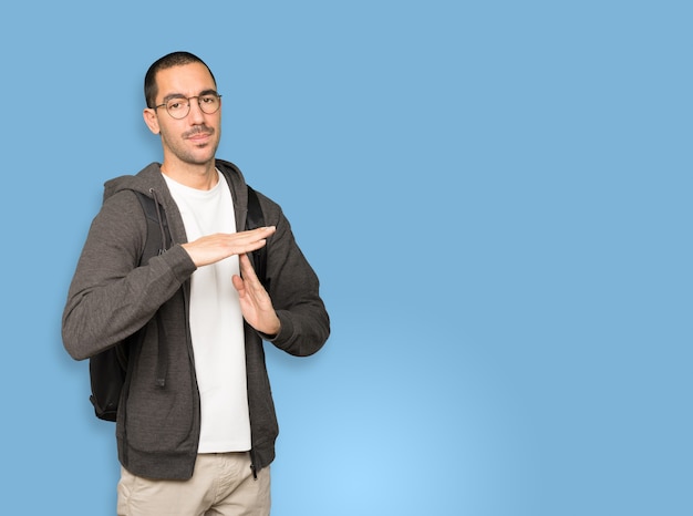 Stressed student making a time out gesture with his hands