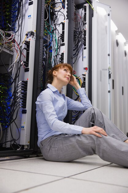 Stressed technician sitting on floor beside open server