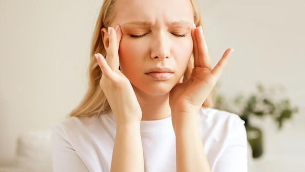 Stressed unhealthy woman feeling tired have terrible strong headache pain.