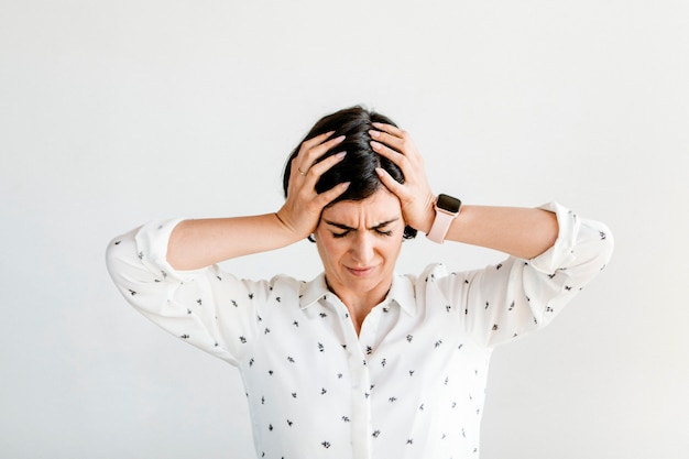 Stressed woman holding her forehead