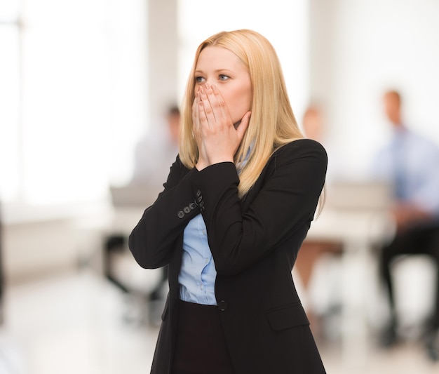 Donna stressata che si tiene la testa con la mano in ufficio