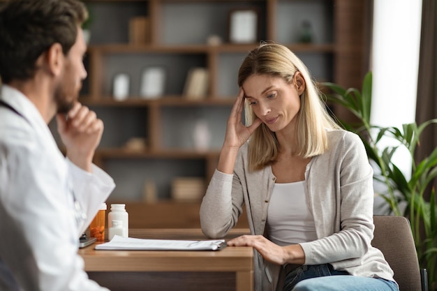 Stressed Woman Looking At Her Check Up Results During Meeting With Doctor